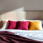 Cuscini letto decorativi su un elegante letto matrimoniale, per un riposo confortevole e di stile.